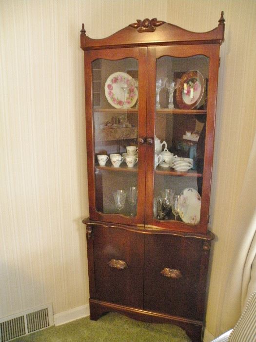 Walnut corner cabinet matches server and chest. Carved leaf pulls. Turned finials.