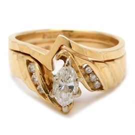 14K Yellow Gold Diamond Bridal Ring Set: A 14K yellow gold bridal ring set including an engagement ring with a center diamond and channel-set diamonds to the shoulder and a zig-zig wedding band.
