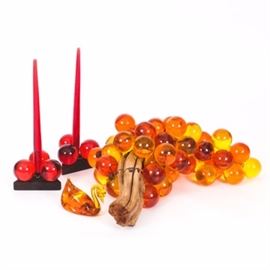 Mid-Century Resin Grape Decor: A grouping of colorful, vintage decor. The main piece in this grouping is a cluster of yellow, orange and red grapes on a sturdy, wooden vine with smaller, coiled wire vines. Also included is a small, plastic yellow swan and two red candlesticks atop of a wooden triangular base with red grape clusters.