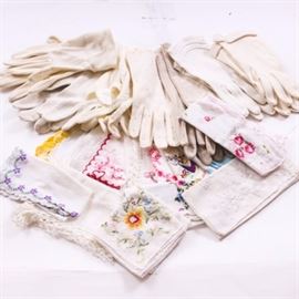 Assortment of Vintage Gloves & Handkerchiefs: An assortment of vintage white hand gloves and handkerchiefs. Totaling seven pairs in total, the hand gloves range in style from classic, plain white gloves to eyelet and embroidered patterns. The ten handkerchiefs feature embroidered florals, lace borders and fine needlework.