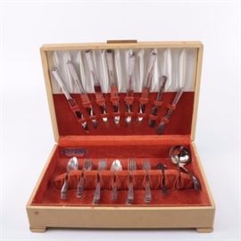 Wm A. Rogers "Capri" Silver Plate Flatware Set: A set of Wm. A Rogers Capri silver plate flatware set. The forty-one piece set was designed in 1935 and features a slightly recessed bands on the edges of the handles with a strip featuring overlapping leaves on the center of the handles. Included in the set are eleven spoons, twenty forks, six knives, three spreaders and a ladle. The set comes in a flatware storage case.