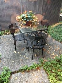 Wrought iron glass top table and four chairs