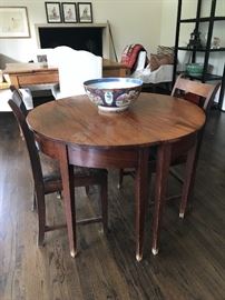 Two demi-lune tables that fit together to create a round game table. Shown with two antique side chairs