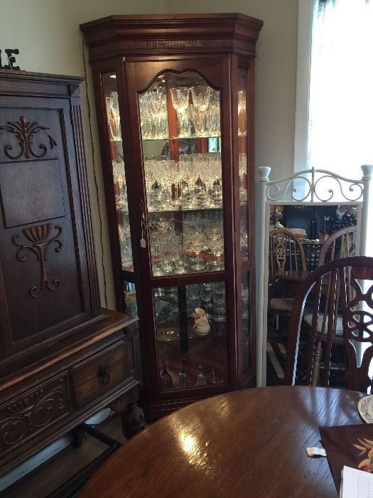 Lighted curio (display) cabinet.  Glass and wood.  Glass shelves are etched for item placement.
Item beside curio is heavy wrought iron standing mirror for bedroom or bath use.  
Table in front.