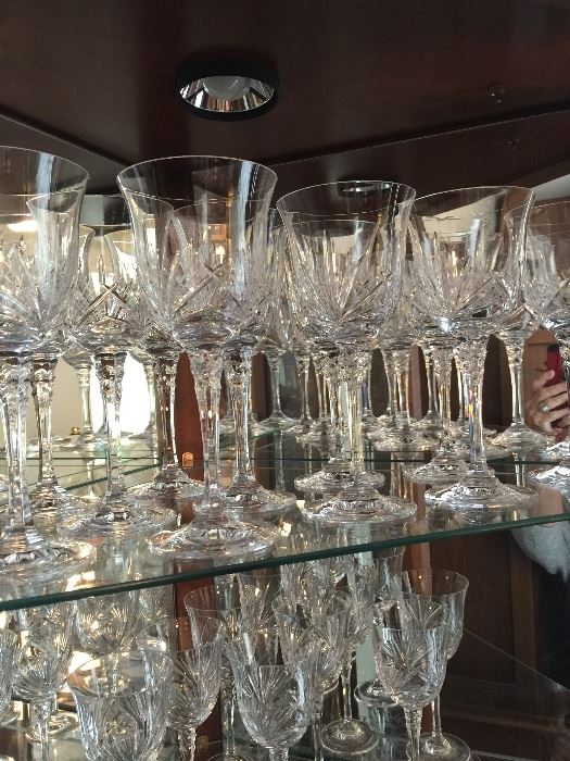 Large number of beautiful cut crystal stemware.  These are the larger water goblets.  Smaller wine glasses complete the set (shown on shelf below).  See other pictures.