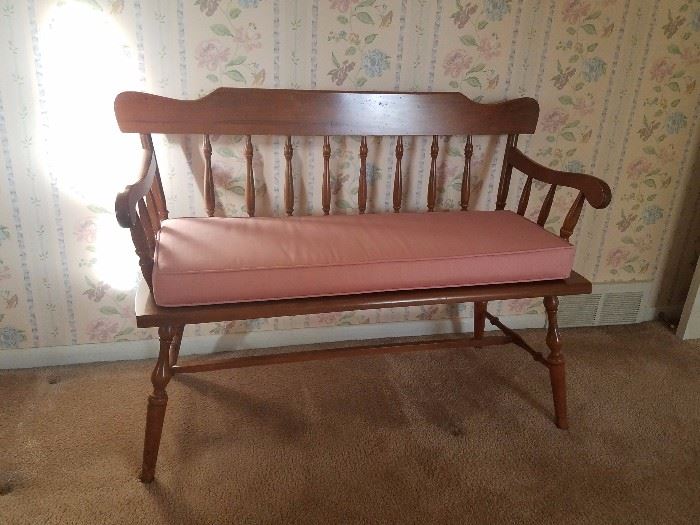 Wood bench seat with cushion.