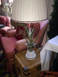 One of two matching lamps on small wicker trunk side tables