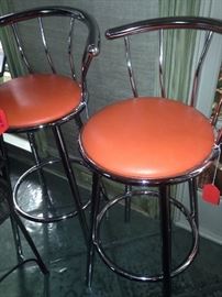 Two orange seat bar stools