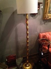 One of two matching gold floor lamps