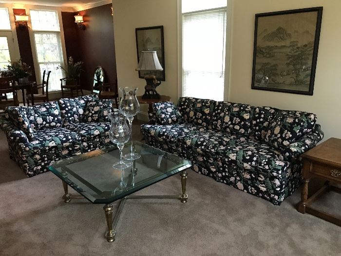 Floral sofa and loveseat, heavy glass and metal coffee table, oriental art