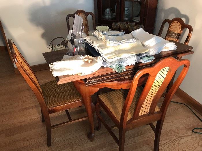 High-end dining room table with 4 chairs that have wicker inserts