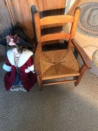 Child's caned chair with antique doll