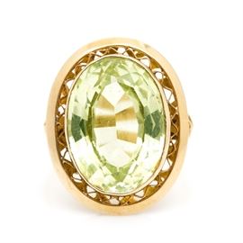 18K Yellow Gold Spinel Ring: An 18K yellow gold synthetic spinel ring. This ring features a center oval faceted spinel held within a pierced bezel setting above a decorative openwork gallery.