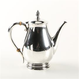 International Silver Co. "Royal Danish" Sterling Silver Coffee Pot: A sterling silver coffee pot by International Silver Co. This pot features the Royal Danish pattern with a pear-shaped body, two inset Bakelite insulators to the scrolled handle, a foliate finial on top of the hinged lid, and a round footed base. The underside is stamped, “Royal Danish, USA”, “International Sterling”, “9 Cups” and “C353 24”. The approximate weight, including all non-sterling materials, is 28.300 ozt.