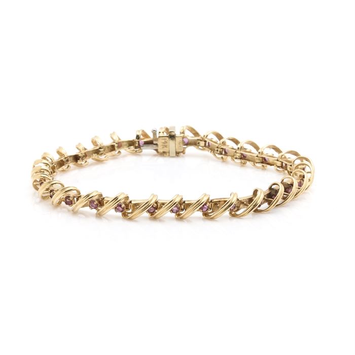 14K Yellow Gold Ruby Hinged Link Bracelet: A 14K yellow gold ruby hinged link bracelet. This bracelet features a decorative hinged link, which is accented with a ruby on each link.