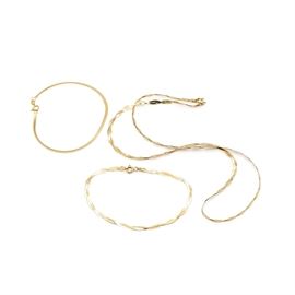 14K Yellow Gold Herringbone Chain Assortment: A 14K yellow gold herringbone chain assortment. This assortment includes two bracelets and one necklace, all made from herringbone chain. The necklace and one bracelet are fashioned from two intertwined lengths of chain.