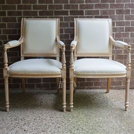 Pair of Louis XVI Style Armchairs by Comini Modonutti: A pair of Louis XVI style armchairs by Comini Modonutti. These chairs feature an upholstered back framed by wood that connects to the seat using fluted stiles. The seat is flanked by flared arms that rise above tapered and fluted legs terminating on arrow feet. The underside is marked with a tag that states “Comini Modonutti.”