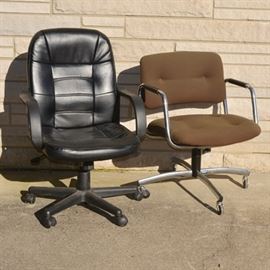 Vintage Office Desk Chairs: A collection of two vintage desk chairs. Chairs feature a faux black leather with fixed loop arms on a black plastic five caster base. The Steelcase brown cloth and chrome metal chair features arched fixed arms on a metal four caster base.