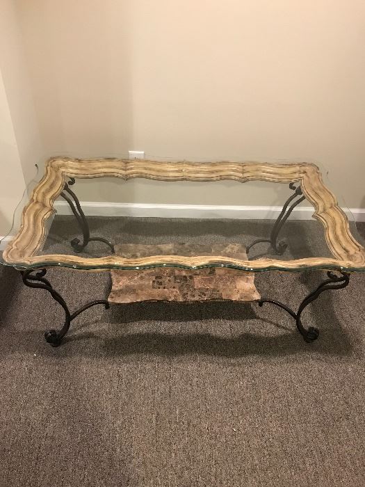 Horchow Glass top coffee table 
Wooden frame 
Beveled glass
Brand new condition 
Wrought iron legs 
Stone shelf 
Dimensions 
Width: 49 inches 
Depth: 28 inches
Height:  19 inches 