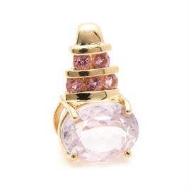 14K Yellow Gold Kunzite and Pink Tourmaline Pendant: A 14K yellow gold kunzite and pink tourmaline pendant. This pendant features a center oval cut kunzite stone above an open gallery and beneath two rows of channel set pink tourmaline stones.