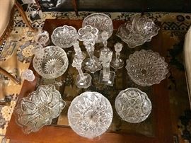 A collection of crystal candlesticks and bowls of various sizes