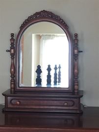 Mirror on top of tall cherry wood dresser