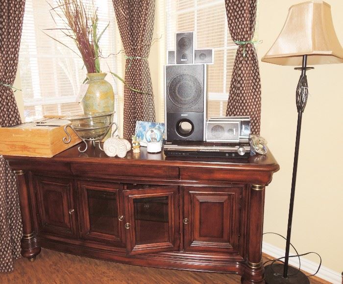 traditional wood console table with glass and solid doors.  Sony surround sound.  Lamps and home decor
