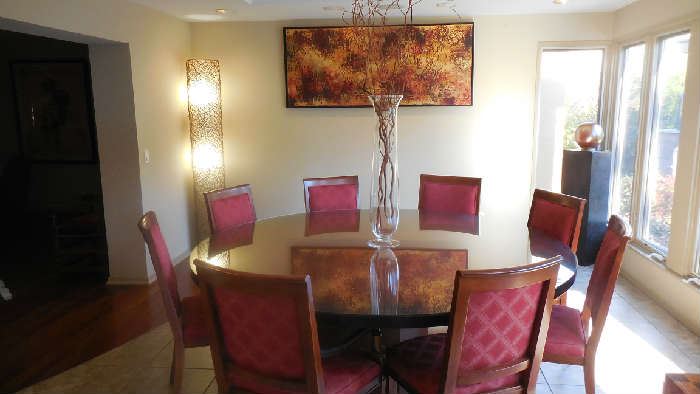 Dining Room:  Nothing promotes lively conversation more than a round table.  This pedestal base table is 6' 8" in diameter and has a glass topper as well. Great for holiday parties or family meetings!  The eight chairs are a perfect pairing but priced separately from the table. The 77" tall "twig" lamp, the large abstract art, the red willow in the glass vase, and the lighted column on the right are also for  sale.  