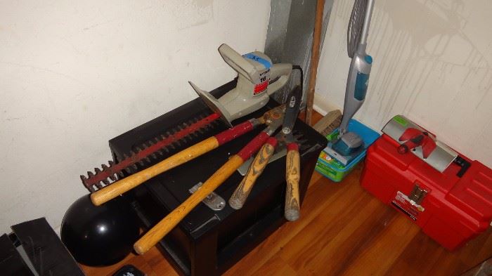 Hedge trimmer, garden tools, floor swifter, tool box,  and bowling ball.   