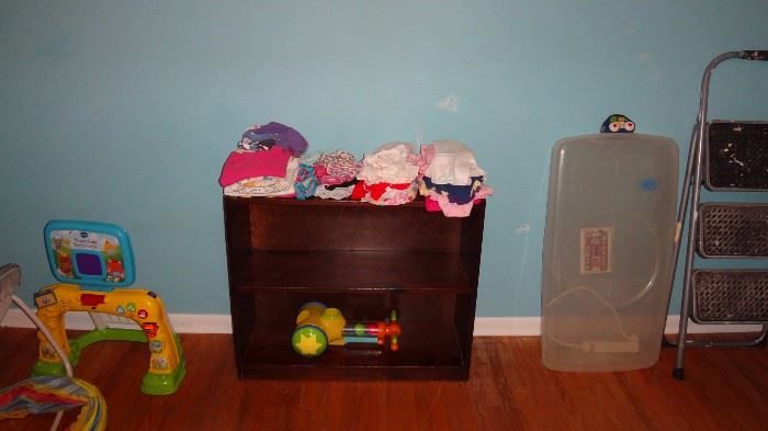 Children's clothing on bookcase, with toys also in same room.   Step ladder to right and under bed storage box. 
