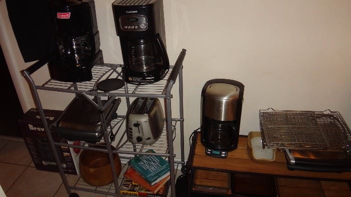Coleman Camping Coffee pot on left, house coffee pots to right.   Toaster.  Breville grills. 