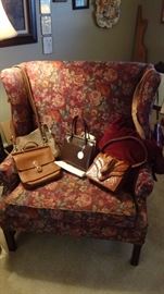 Oversized chair with vintage quality purses.   Alligator, Coach, Dooney & Burke, all authentic.  