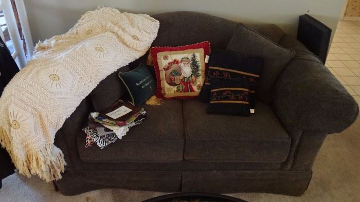 Couch with unused handmade beautifully crocheted bedspread, vintage scarves.   