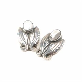 Georg Jensen Sterling Silver Foliate Clip-On Earrings: A pair of sterling silver clip-on earrings by Georg Jensen. These earrings each feature two scrolling leaf motifs crowned by an oval accent.