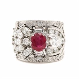 Platinum 1.65 CT Ruby and 3.67 CTW Diamond Ring with GIA Report: A platinum 1.65 ct ruby and 3.67 ctw diamond ring with GIA report. This three part fused custom ring features a center oval ruby set between diamond set foliate shoulders bordered by stamped scrolled and foliate details accented with diamonds. This ring is accompanied by a GIA ruby origin report.