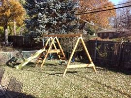 Wooden playset with two swings, slide and glider