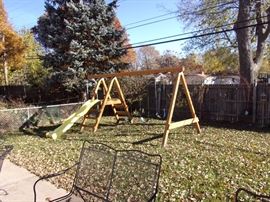 Wooden playset with two swings, slide and glider