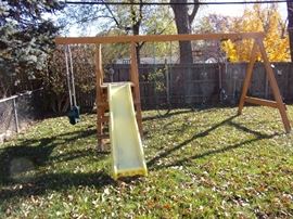 Wooden playset with two swings, slide and glider