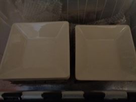 Boxes of white ceramic plates and serving pieces