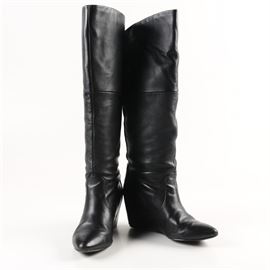 Women's Report Leather Knee-High Wedge Boots: A pair of knee-high wedge boots by Report, the Waldron, in a size 9. The boots are comprised of a black leather at a knee height and feature curved front shafts and integrated wedge heels with rounded point toes. The boots include a brand label to the interior.