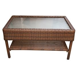 Wicker Wrapped Patio Coffee Table: A wicker wrapped patio coffee table. This rectangular patio table features a glass top in a wicker wrapped frame. Table has a thick apron, bottom shelf and stands on straight wrapped legs.