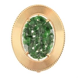 14K Yellow Gold Jadeite Converter Brooch: A 14K yellow gold jadeite converter brooch. This brooch showcases a carved, dyed jadeite presenting a floral theme, accented by a yellow gold ridged halo. There are hidden bails to the reverse which would allow for the brooch to hang as a vertical pendant.