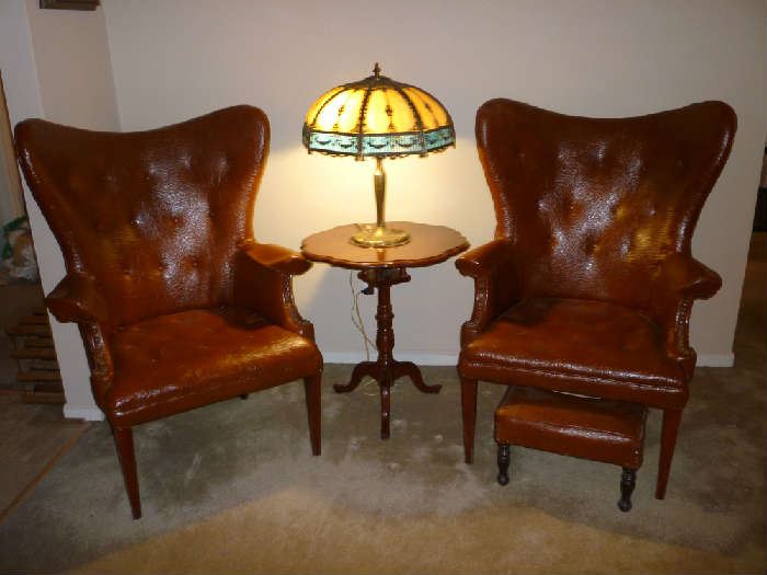 2 VINTAGE BROWN LEATHER ARM CHAIRS (1 W/STOOL), WOOD SIDE TABLE, BEAUTIFUL TIFFANY STYLE LAMP