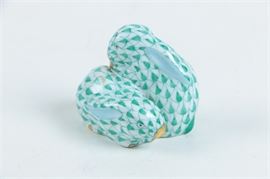 Herend Hungary Pair of Rabbits: A Herend Hungary pair of rabbits figurine. This figurine depicts a pair of rabbits sitting next to each other. They are hand painted in green and white with gold toned accents. It is marked “Herend Hungary” to the underside and is numbered “33”.