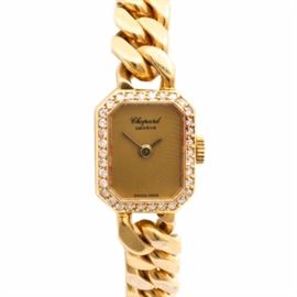 Chopard 18K Yellow Gold Diamond Wristwatch: A Chopard 18K Yellow Gold 0.24 ctw diamond wristwatch. This wristwatch features an 18K yellow gold flat curb link chain bracelet, which is attached to a chamfered corner rectangle, that is framed with a row of diamonds. The case houses a gold tone dial, with gold tone hands.