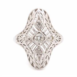 14K White Gold Diamond Ring: A 14K white gold 0.18 ctw diamond ring. This ring showcases a vertically elongated crown decorated with filigree detail. There are five diamonds found at the rings crown, one placed centrally and the others surrounding in all cardinal directions.