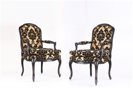 Pair of Gold and Black Damask Upholstered Armchairs: A pair of damask patterned upholstered armchairs. Featuring a beautiful gold and black damask pattern, each chair consists of a black painted wood frame with a classic cabriole legs and whorl feet. The upholstered seat, back and arm cushions are all lined with two rows of matching upholstery cording.
