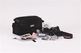 Canon Rebel T3i EOS 600D Camera: A 2011 Canon Rebel T3i camera. The camera is a EOS 650D made by Canon. Serial number of 162057006589. A 55mm lens is included on the camera. A camera bag, Belkin mini HDMI cable, original software discs and manuals, AV cables, lens caps and wipe, USB cord and neck strap are also included.