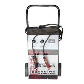 Schumacher SE-4220 Battery Charger/Engine Starter: A Schumacher battery charger/engine starter. This Schumacher model SE-4220 maintains 40 ampere boost, and 200 ampere engine start. It features two wheels and a handle for portability.