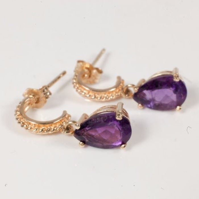 14K Yellow Gold and Pear-Cut Amethyst Dangle Earrings: A pair of 14K yellow gold dangle earrings. Each earring features one faceted pear cut amethyst dangling from a 14K yellow gold half hoop decorated with a twisted design.